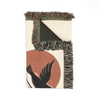 Textile with fringes and a bird design on a white background