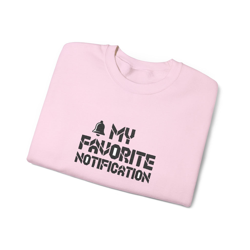 Folded pink sweatshirt with 'My Favorite Notification' text on a white background