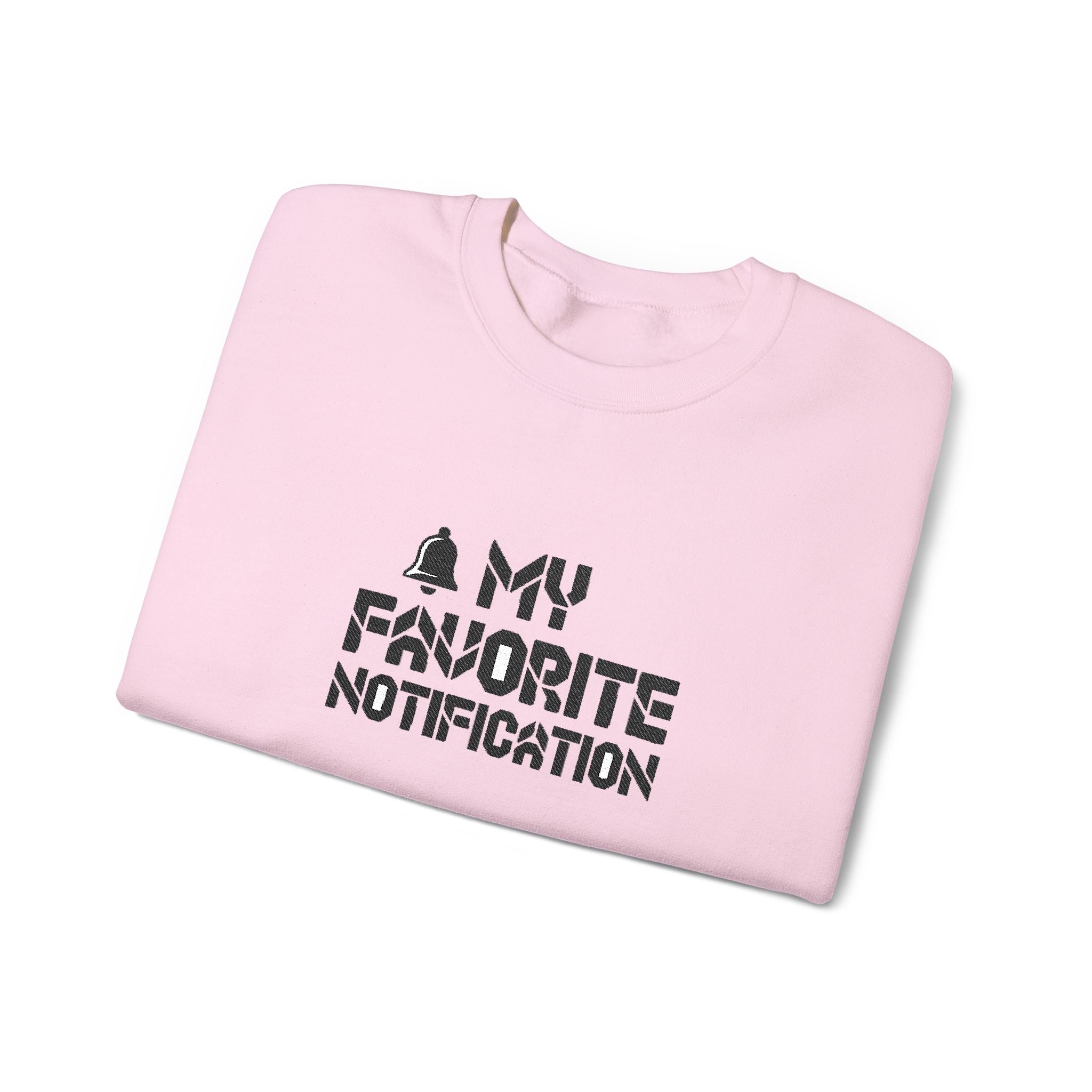 Folded pink sweatshirt with 'My Favorite Notification' text on a white background