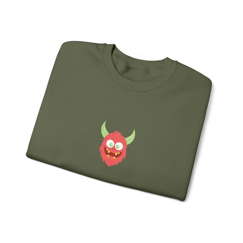 Folded green sweatshirt with a red monster design on a white background