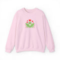 Pink sweatshirt with a green frog and red hearts design on a white background