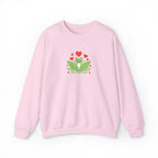 Pink sweatshirt with a green frog and red hearts design on a white background