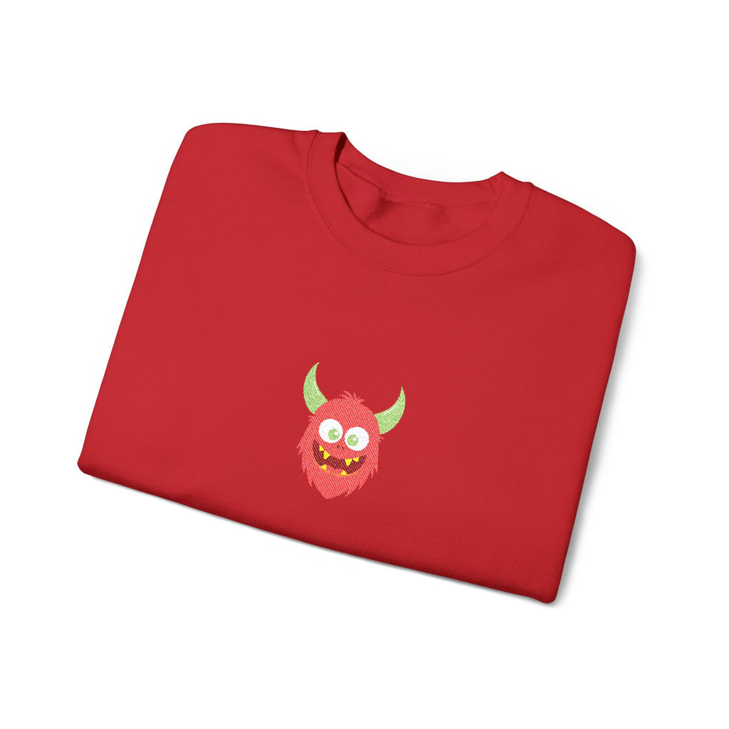 Folded red sweatshirt with a cartoon monster design on a white background