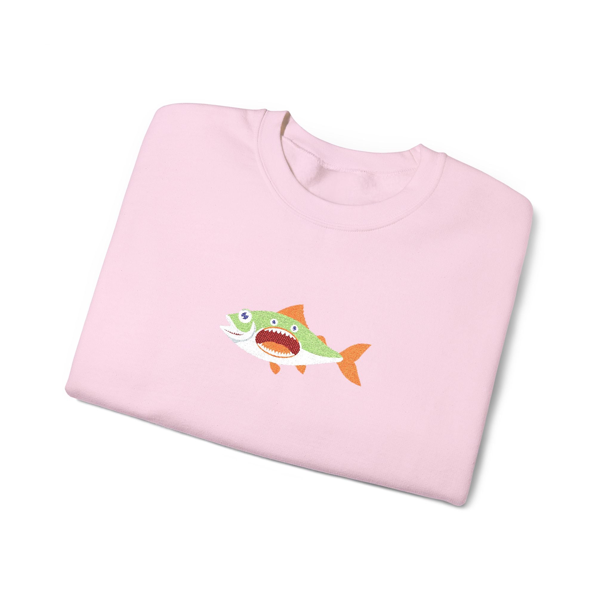 Folded pink sweatshirt with a fish graphic on a white background