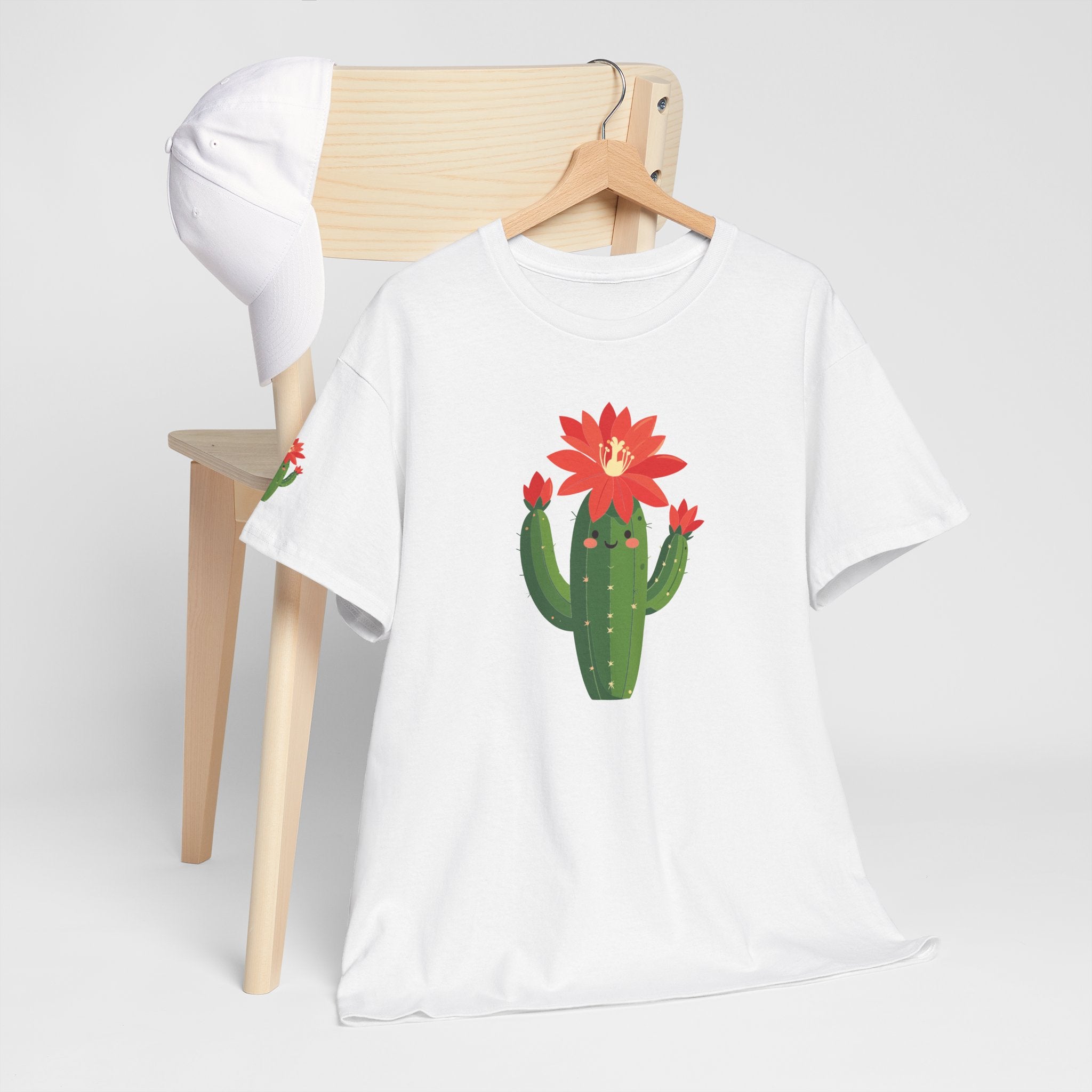 White t-shirt with a cactus and flower design on a wooden chair against a white background