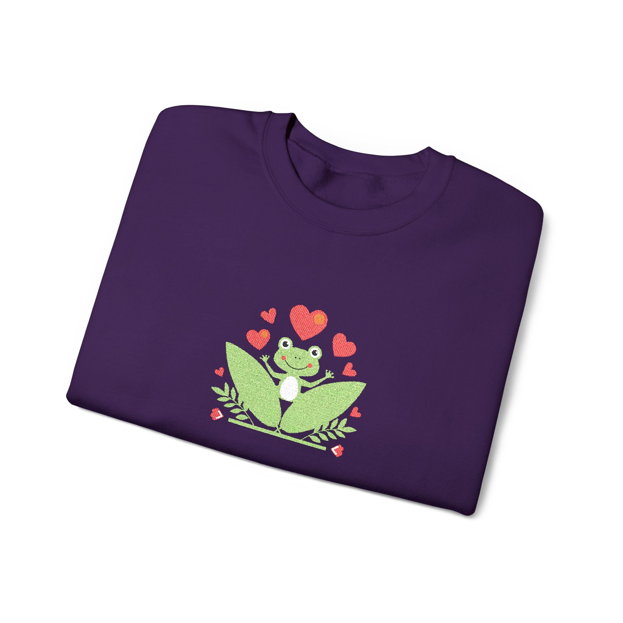 Folded green t-shirt with a frog and heart design on a white background