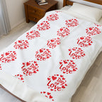 Bedspread with 'Day of Love' text and heart patterns on a bed in a bedroom.