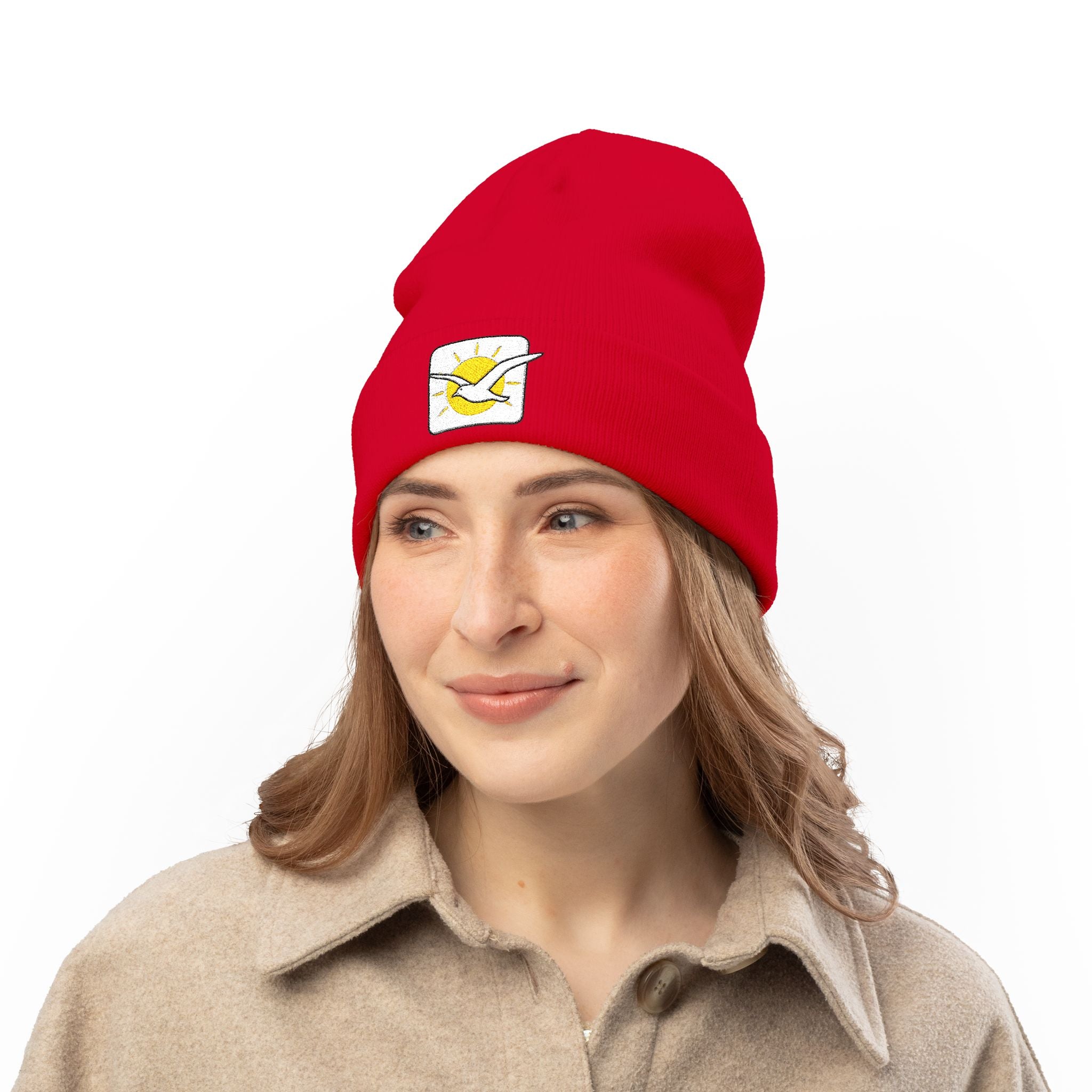Person wearing a red beanie with a logo on a white background