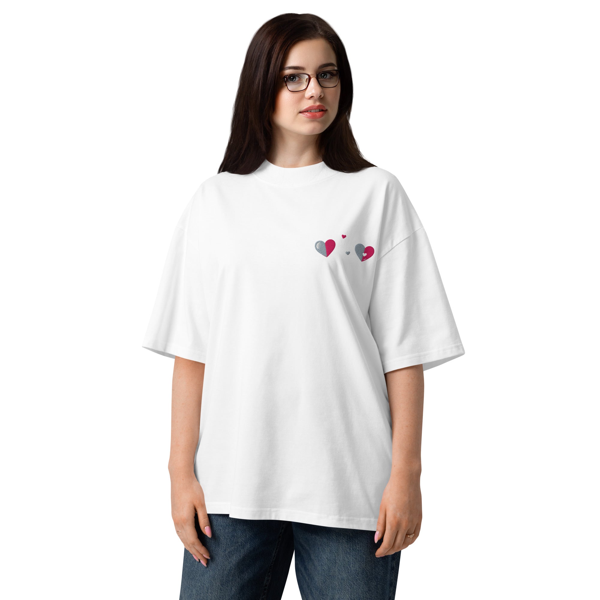 Person wearing a white t-shirt with heart designs on a plain background