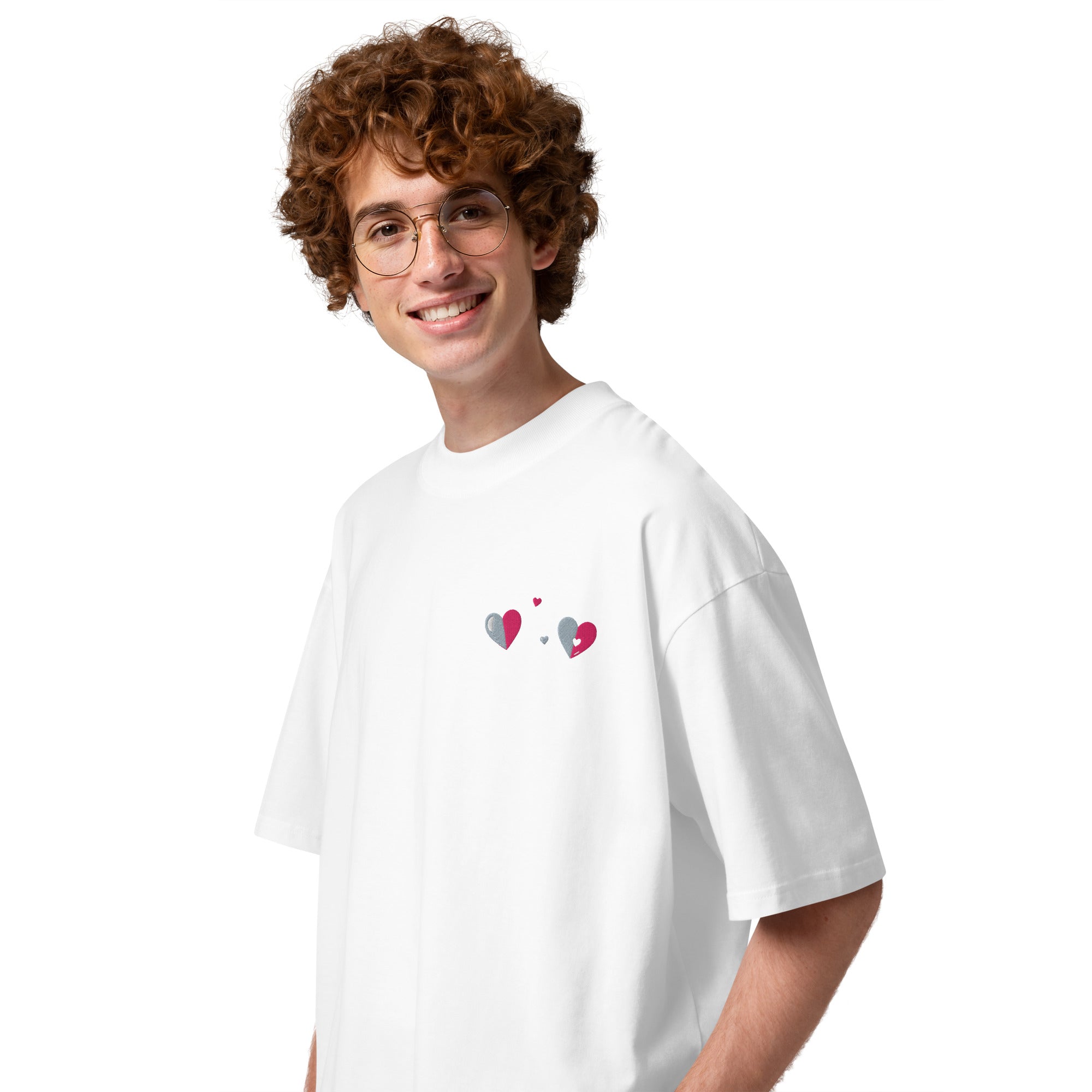 Person wearing a white t-shirt with heart designs on a plain background