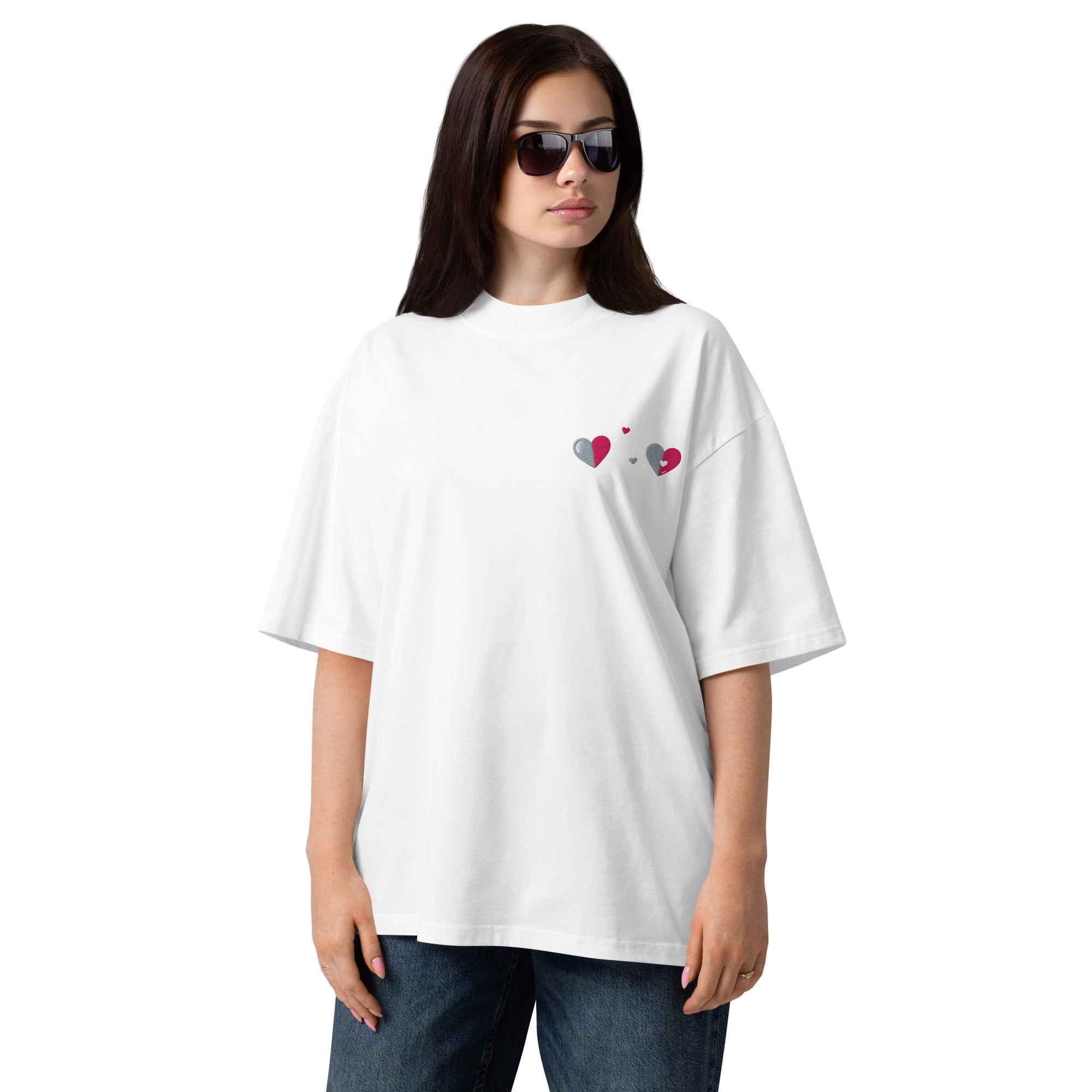 Woman wearing a white oversized t-shirt with heart designs on a white background