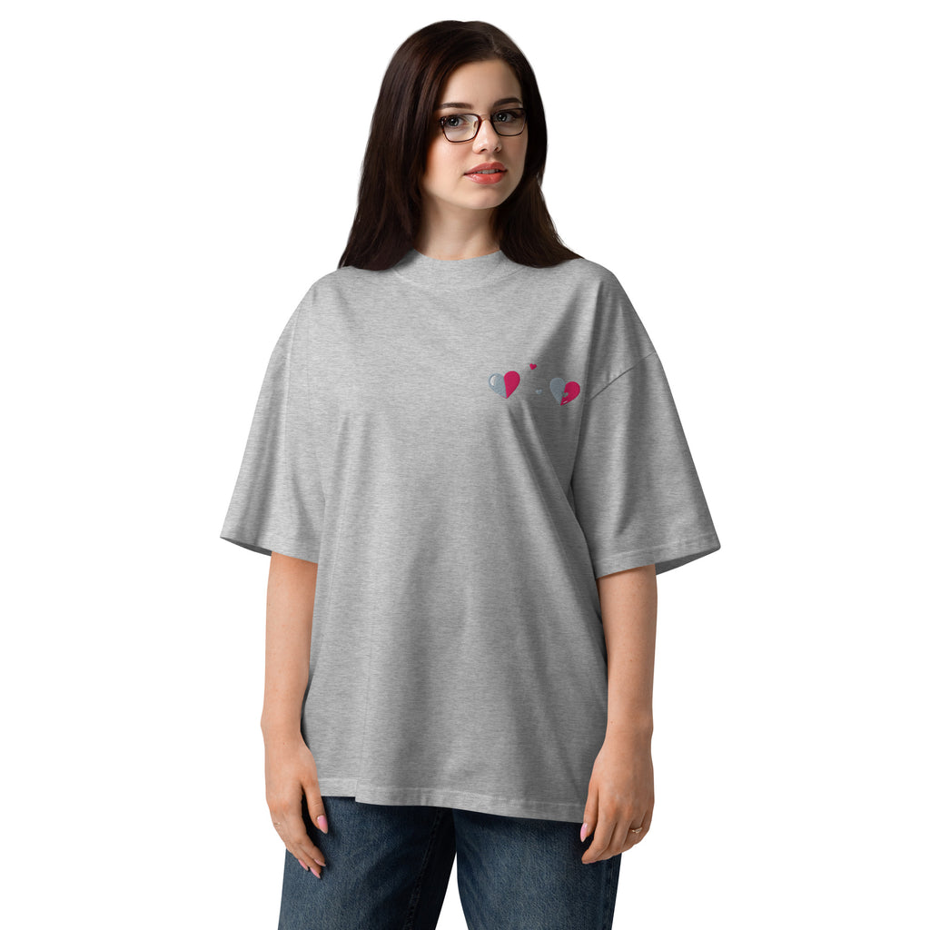 Person wearing a gray oversized t-shirt with a small design on a white background