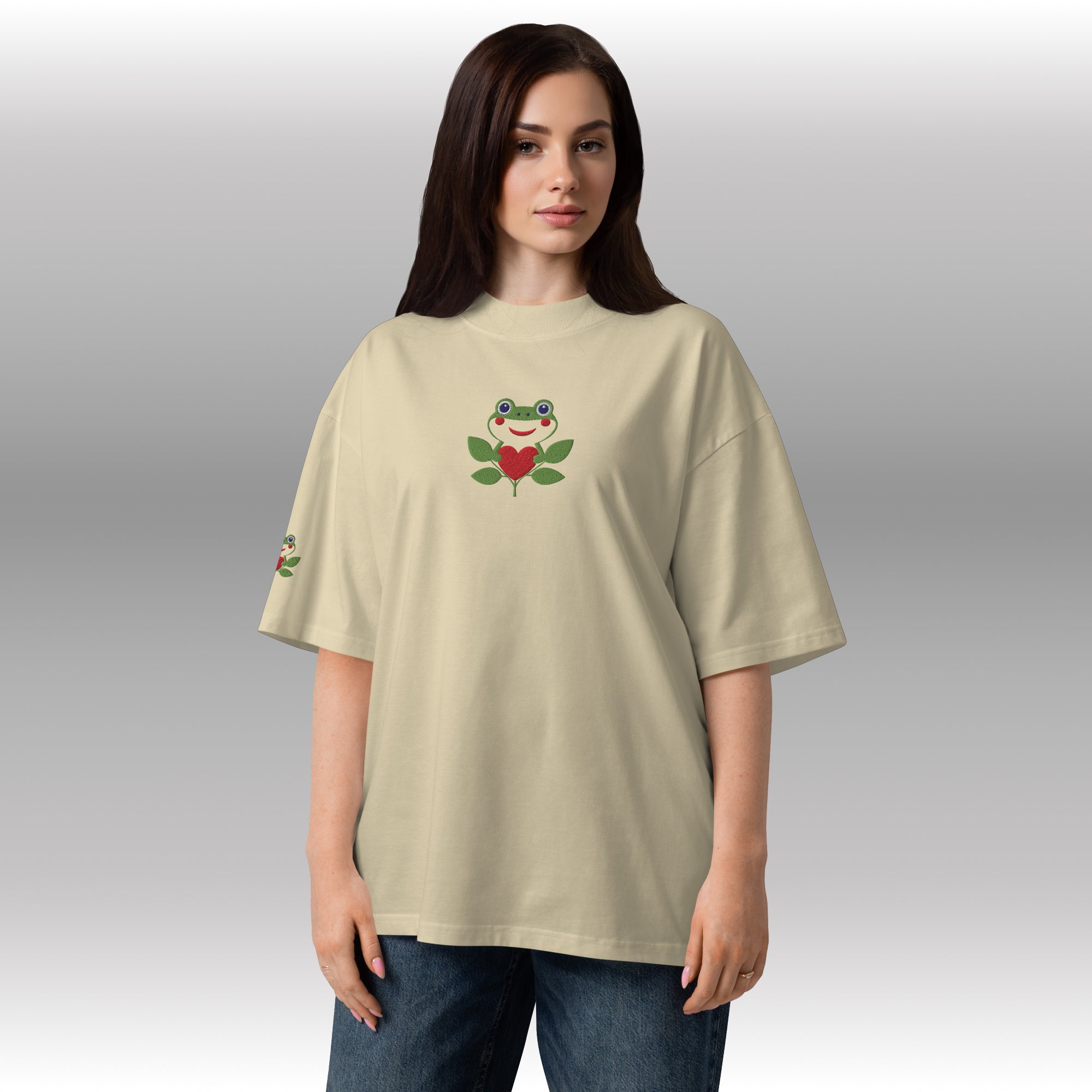 Woman wearing a beige t-shirt with a frog design on a gray background