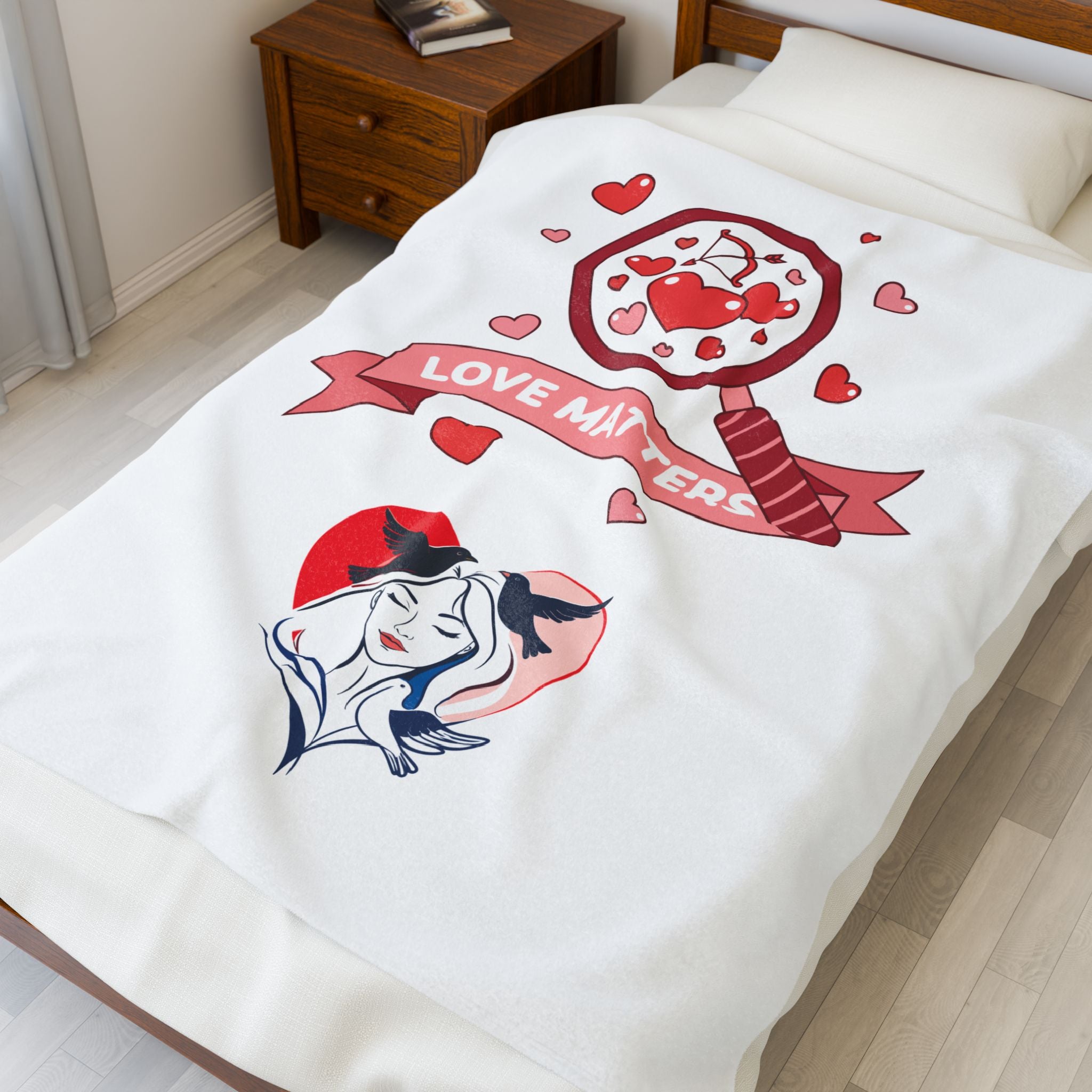 White blanket with a graphic design featuring hearts and text on a bed in a bedroom.