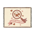 Blanket with 'Love Matters' design featuring hearts and an arrow on a beige background