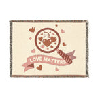Blanket with 'Love Matters' design featuring hearts and an arrow on a beige background
