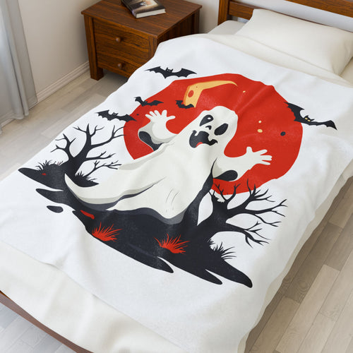 Halloween-themed blanket with ghost design on a bed