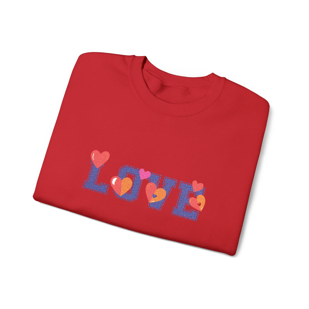 Folded red sweatshirt with colorful 'LOVE' text on a white background