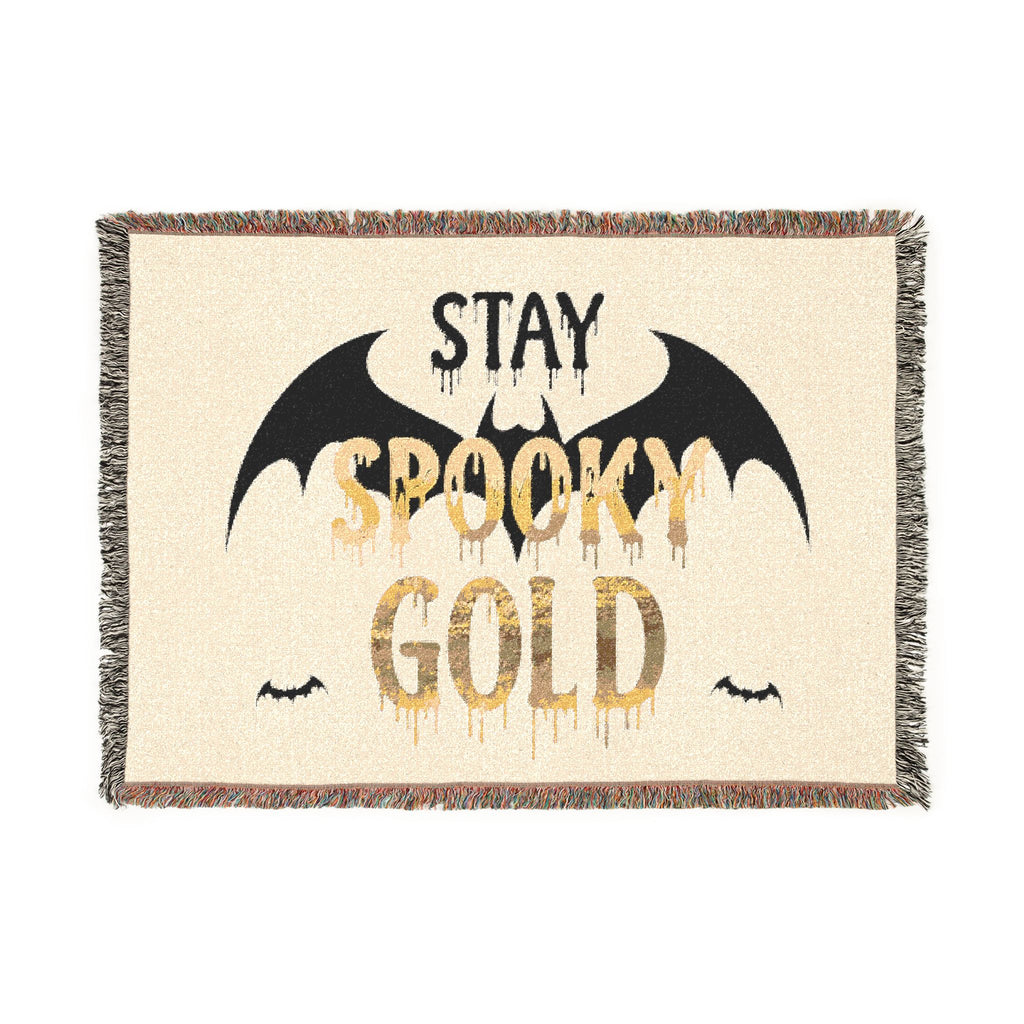 Blanket with 'Stay Spooky Gold' text and bat designs on a beige background