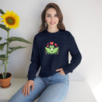 Woman wearing a navy blue sweatshirt with a frog design, sitting next to a sunflower.