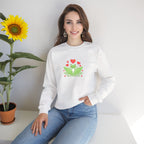 Woman wearing a white sweatshirt with a graphic design sitting next to a sunflower.