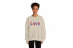 Person wearing a beige sweatshirt with colorful 'LOVE' text on a white background