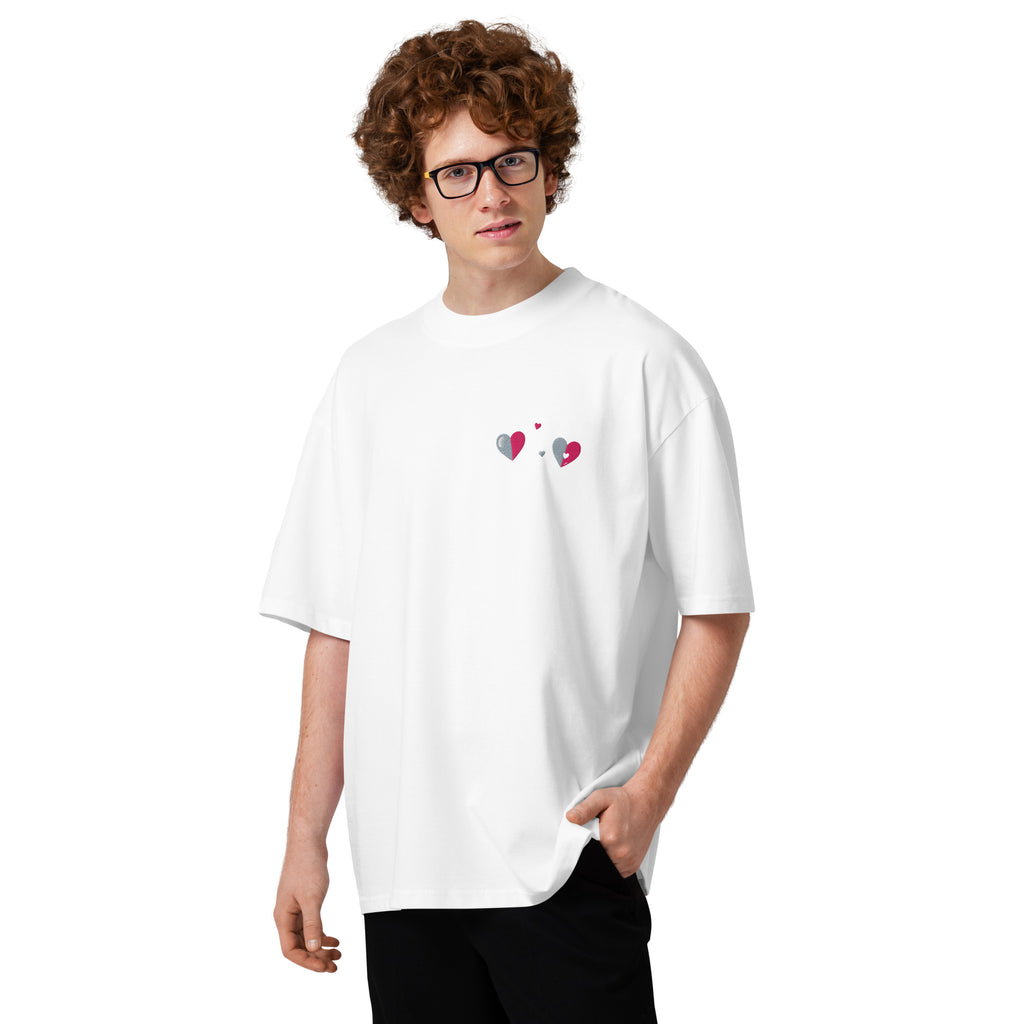 Person wearing a white t-shirt with colorful heart designs on a white background