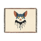 Woven blanket with a dog illustration and dripping black paint on a beige background