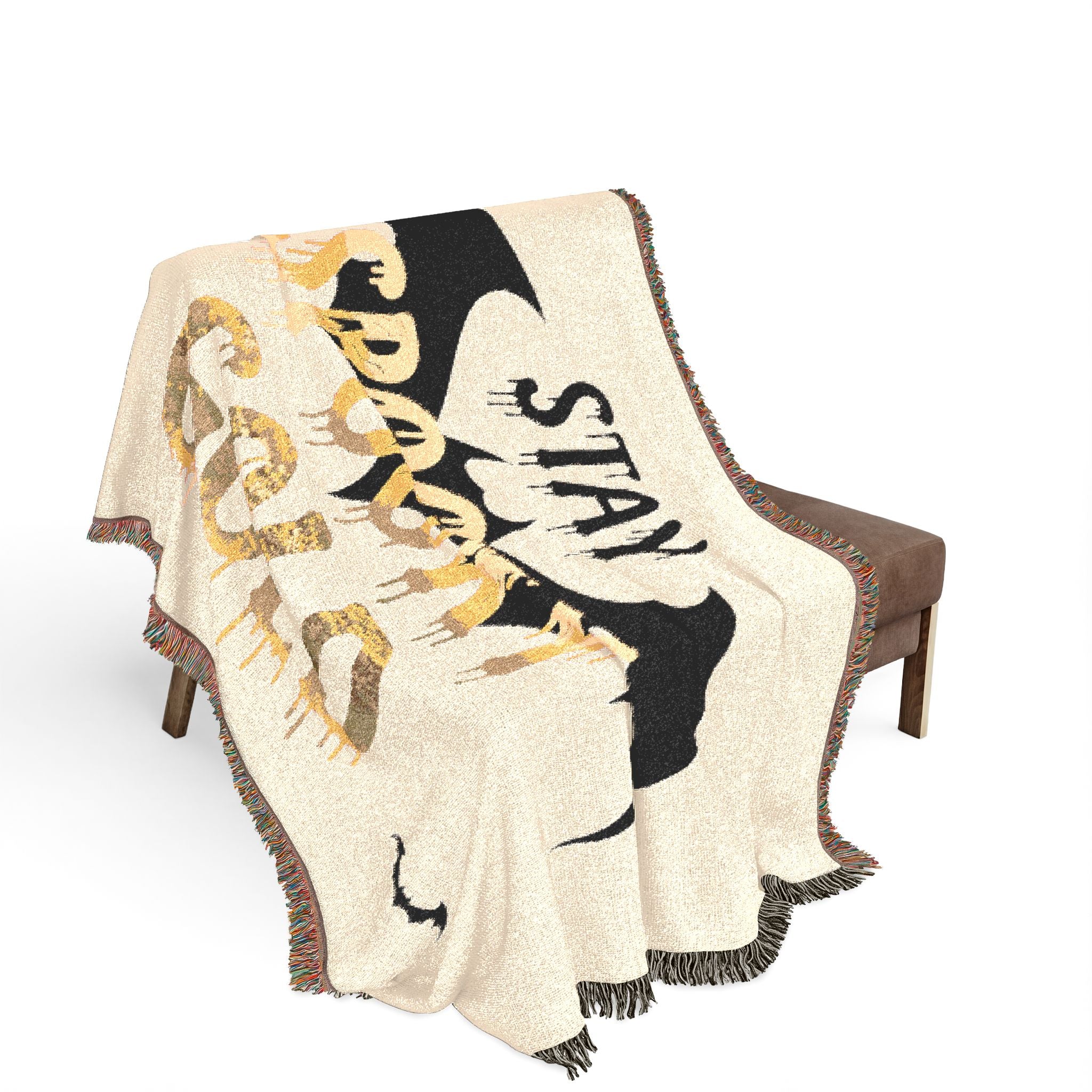 Decorative blanket with artistic design and text draped over a chair on a white background