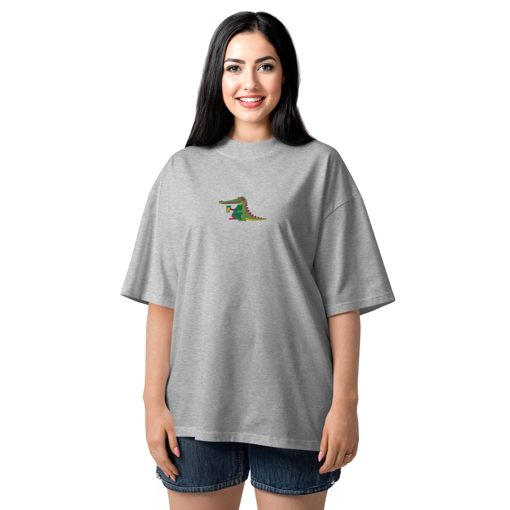 Woman wearing a gray oversized t-shirt with a colorful graphic on a white background