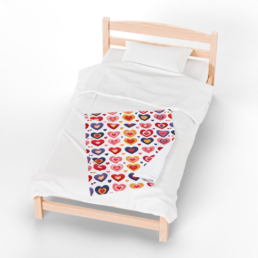 Children's bed with a colorful heart-patterned duvet cover on a white background