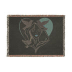 Blanket with a design of a woman's face and birds in a heart shape on a black background