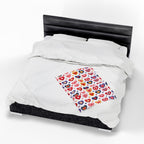 White comforter with a colorful heart-patterned pillow on a bed with black headboard.