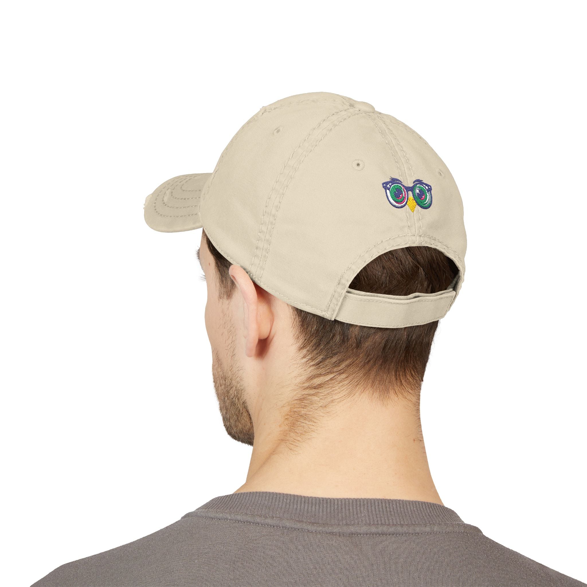 Beige cap with a logo worn by a person on a white background