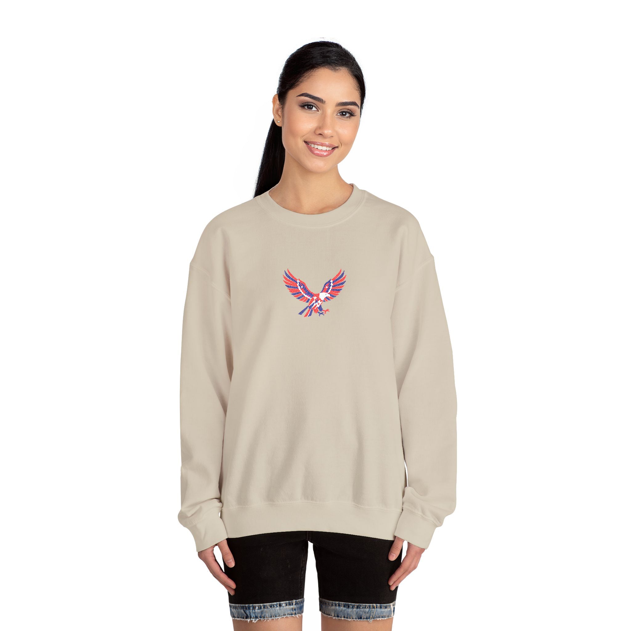 Woman wearing a beige sweatshirt with a colorful eagle design on a white background