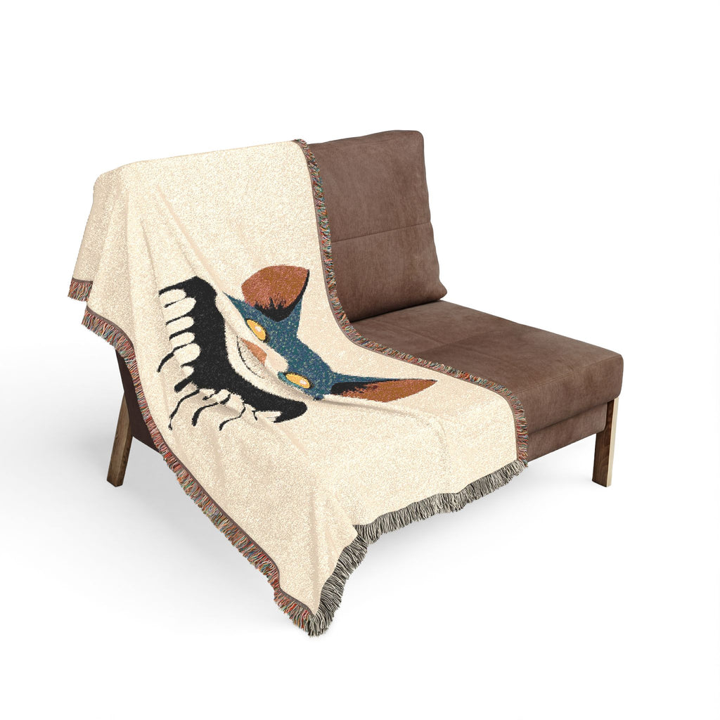 Brown chair with a decorative blanket featuring a bird design on a white background