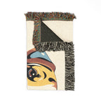 Decorative rug with colorful fringe and abstract design on a white background