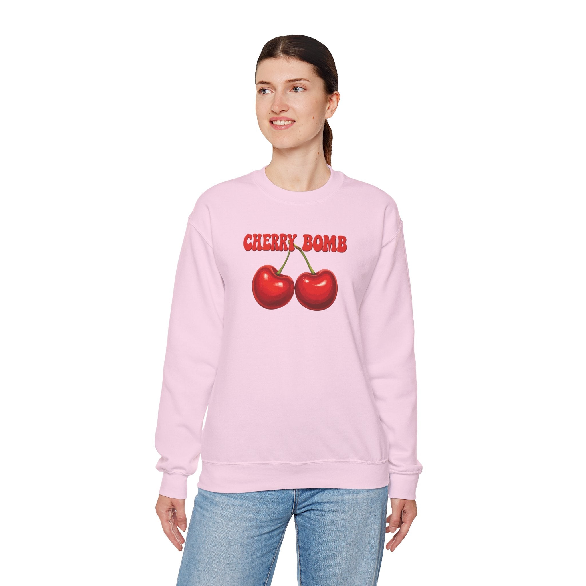 Person wearing a pink sweatshirt with cherry design and 'Cherry Bomb' text on a white background