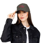 Woman wearing a dark gray cap with red text, black jacket, and white shirt on a white background