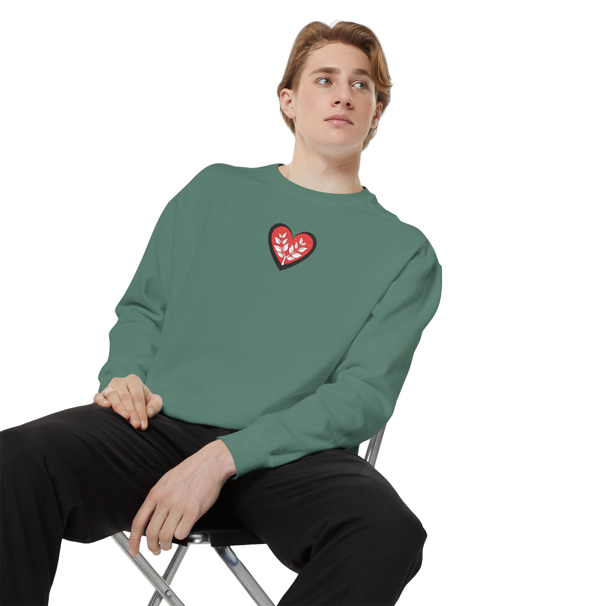 Person wearing a teal long-sleeve shirt sitting on a chair against a white background