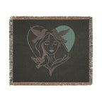 Blanket with a design of a woman's face and birds in a heart shape on a black background