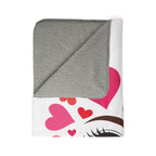 Folded blanket with gray top and colorful heart pattern on white background