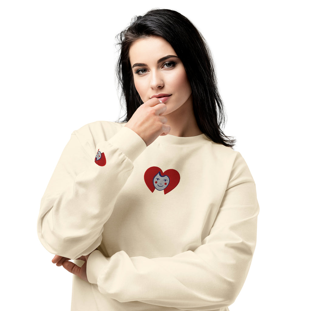 Woman wearing a cream-colored sweatshirt with heart designs on a white background