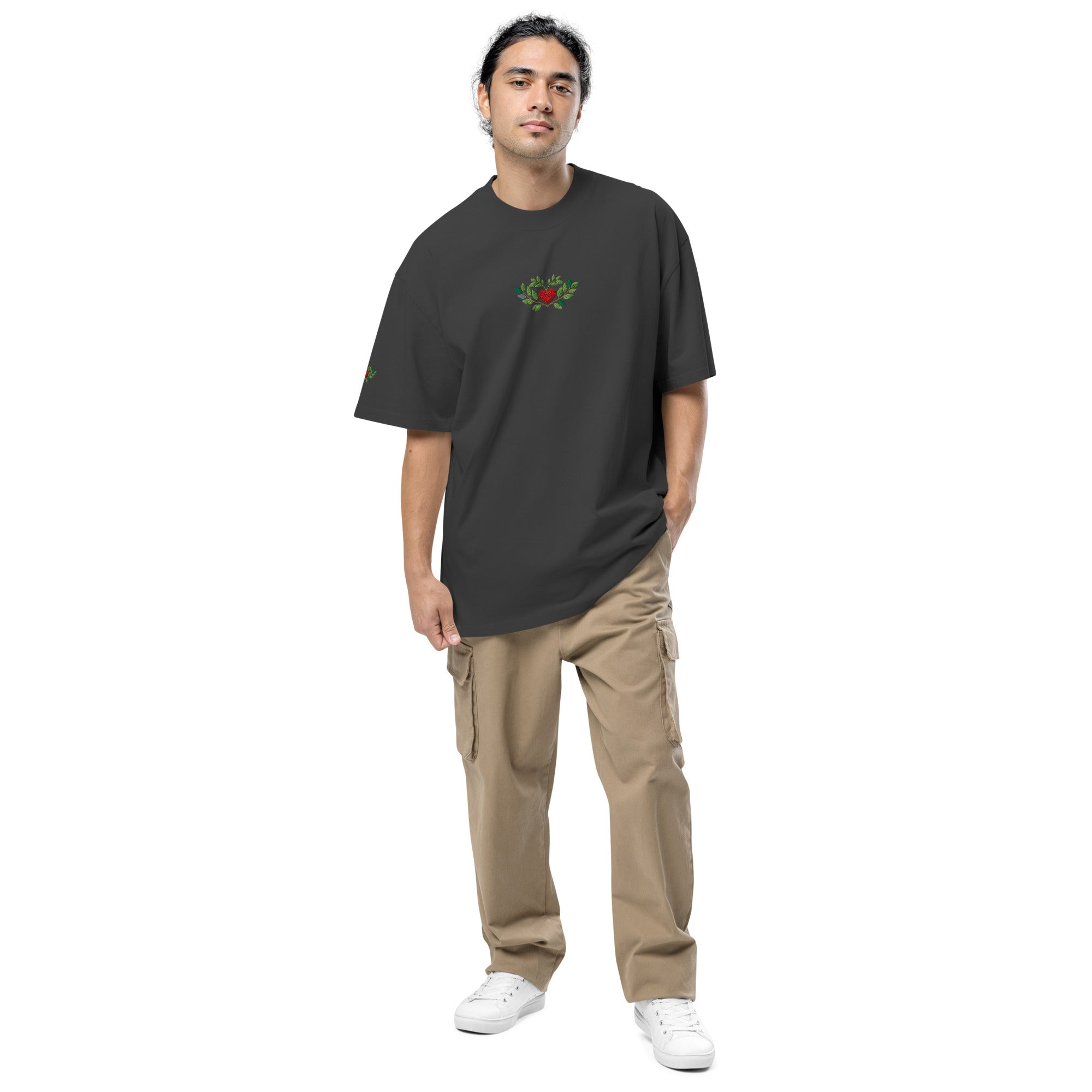 Man wearing a black t-shirt with a logo and beige pants on a white background