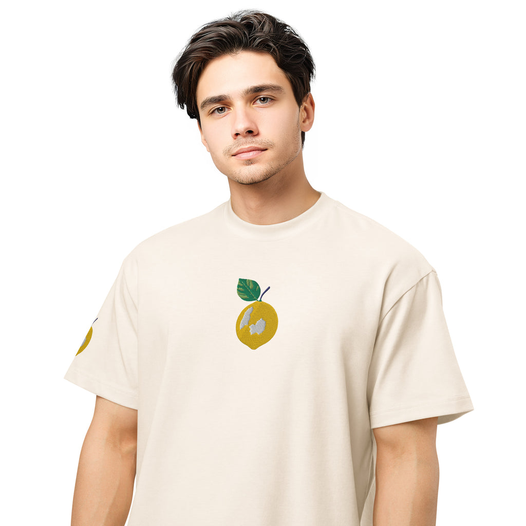 Man wearing a beige t-shirt with a graphic design on a white background