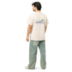 Man wearing a beige t-shirt with a logo on the back, standing against a white background