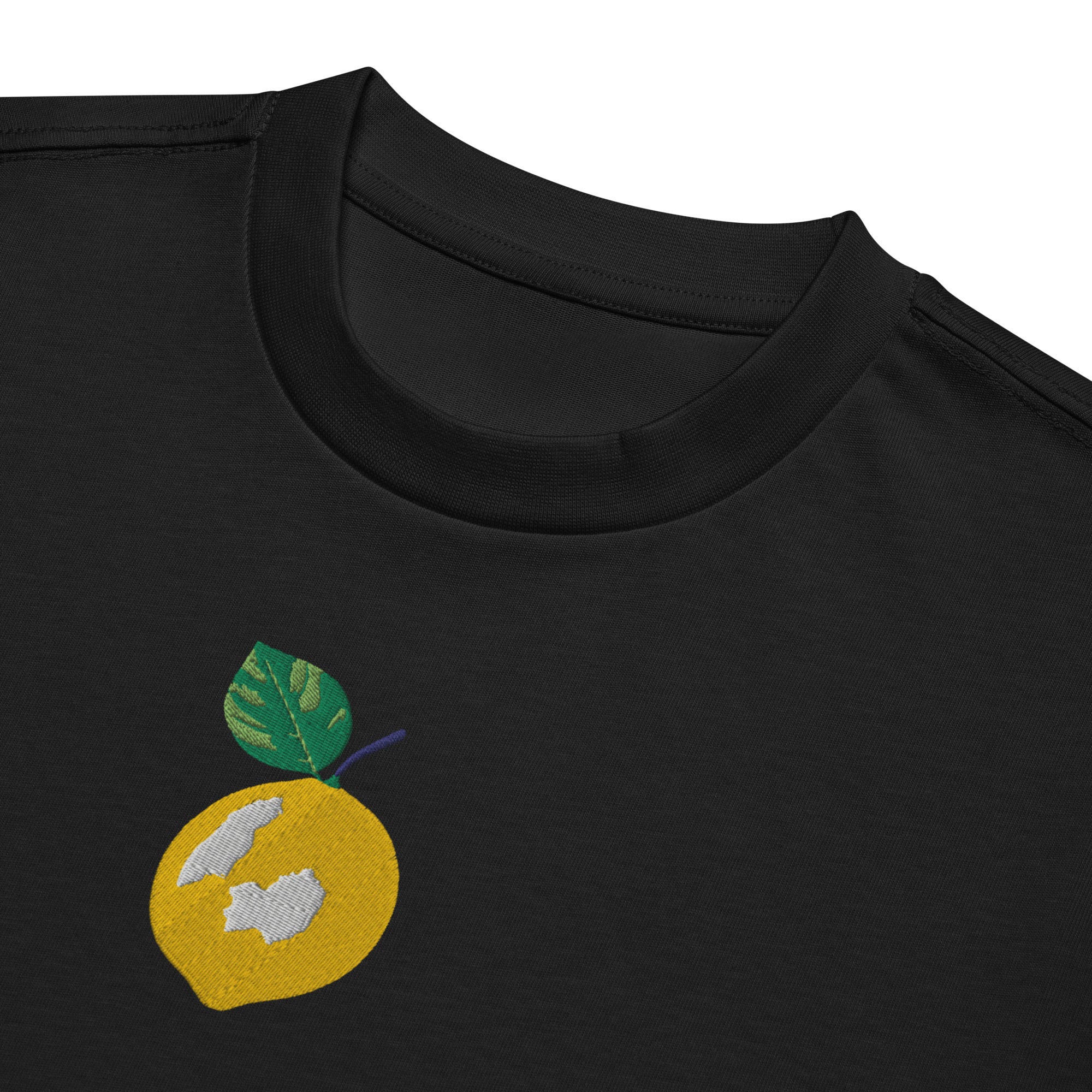 Black t-shirt with a yellow circle design featuring a leaf and abstract shapes on a white background