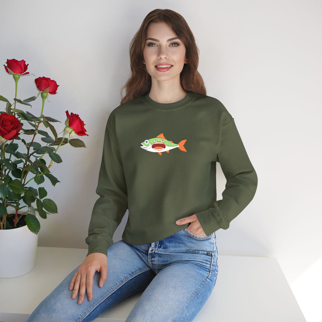 Woman wearing a green sweatshirt with a fish graphic, sitting next to a potted plant with red flowers.