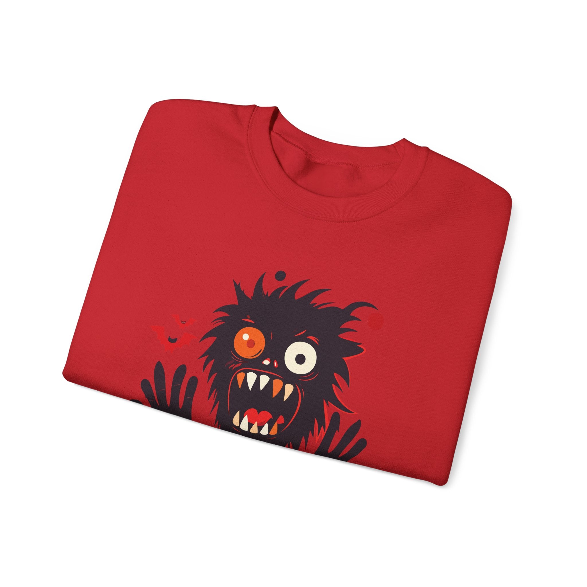 Folded red t-shirt with a black and orange monster design on a white background