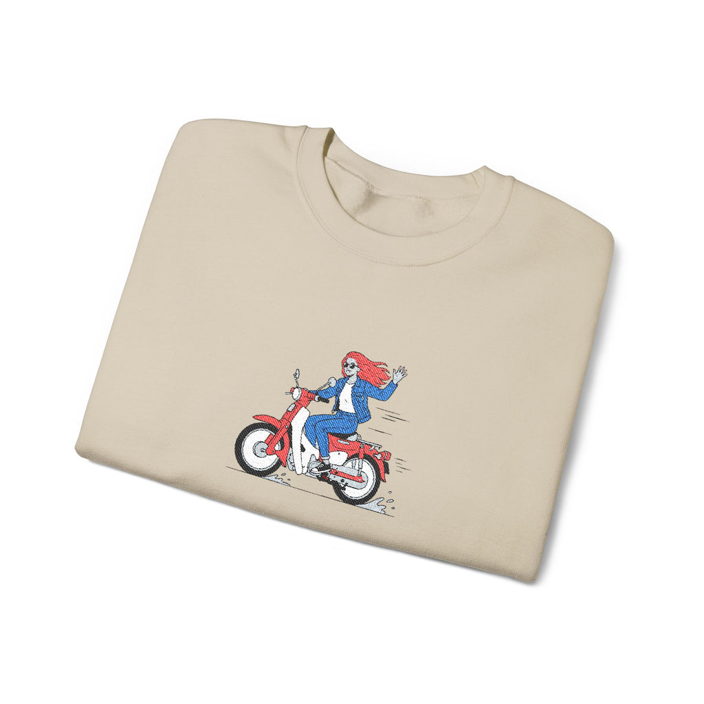 Beige t-shirt with a graphic of a person on a motorcycle on a white background